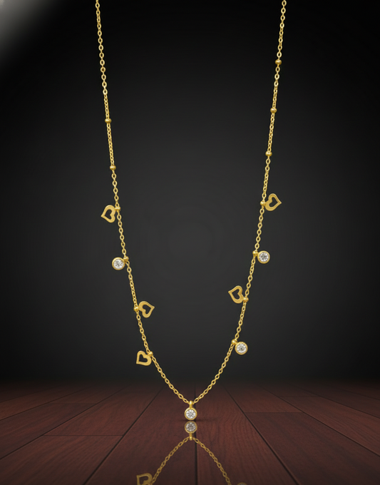 Gold necklace with heart and gemstone pendants on a dark background