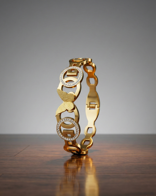 Gold bracelet with diamond accents on a wooden surface and gray background